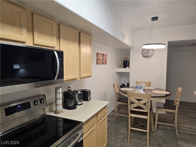 kitchen with dark hardwood / wood-style floors, light brown cabinets, stainless steel appliances, and decorative light fixtures