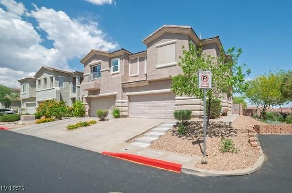 view of front of home featuring a garage, stucco siding, and driveway
