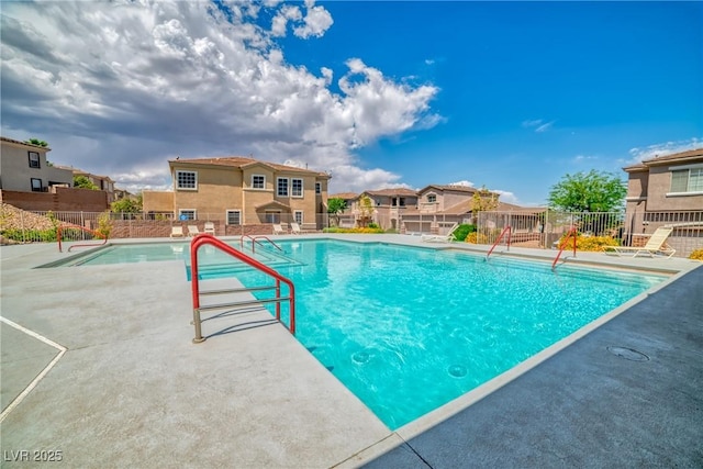 view of pool featuring a fenced in pool, a patio area, fence, and a residential view
