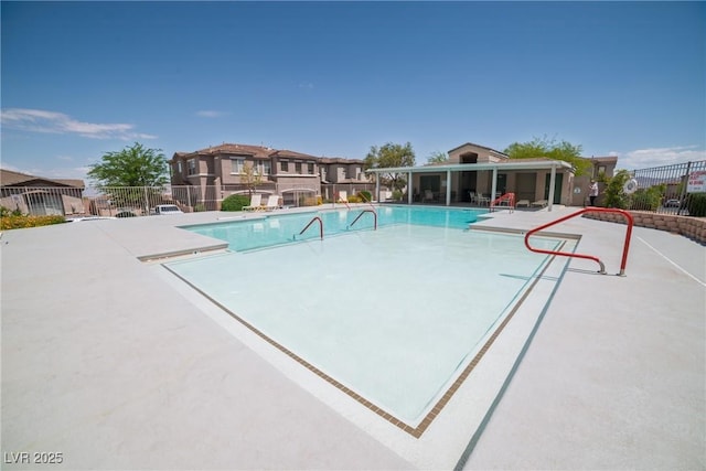community pool featuring fence and a patio area