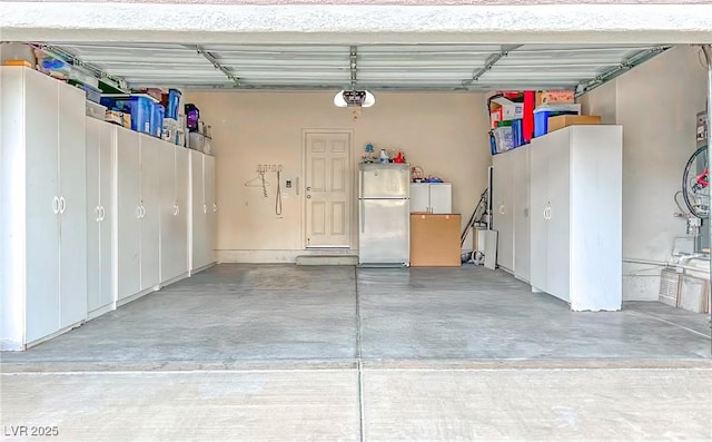 garage featuring freestanding refrigerator and a garage door opener