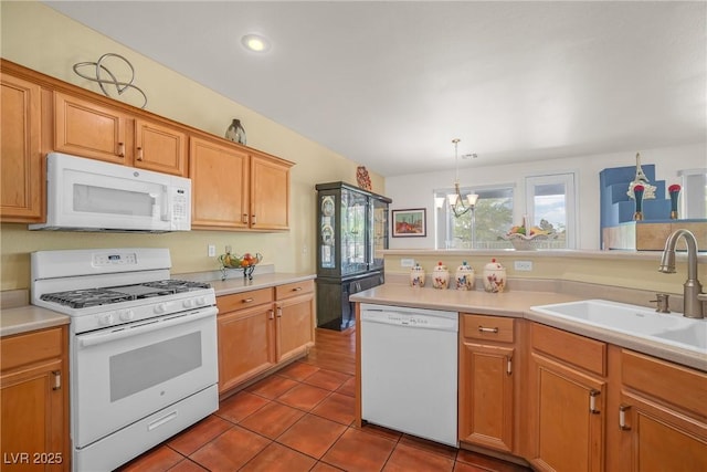 kitchen featuring an inviting chandelier, a sink, white appliances, and light countertops
