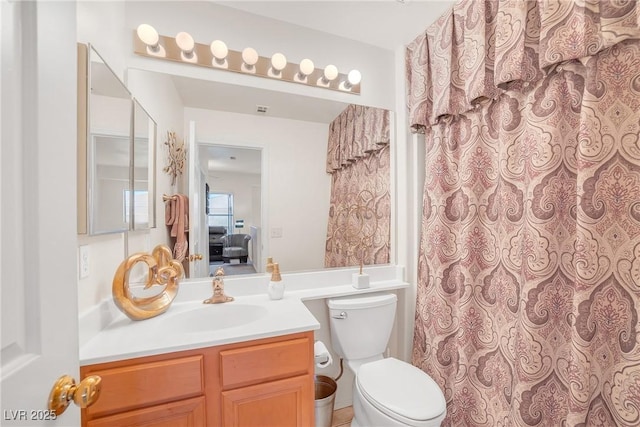 full bath featuring vanity, toilet, and curtained shower