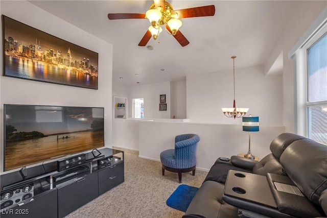 living room with carpet floors, baseboards, and ceiling fan with notable chandelier