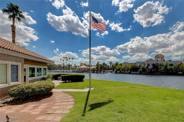 view of community featuring a water view and a lawn