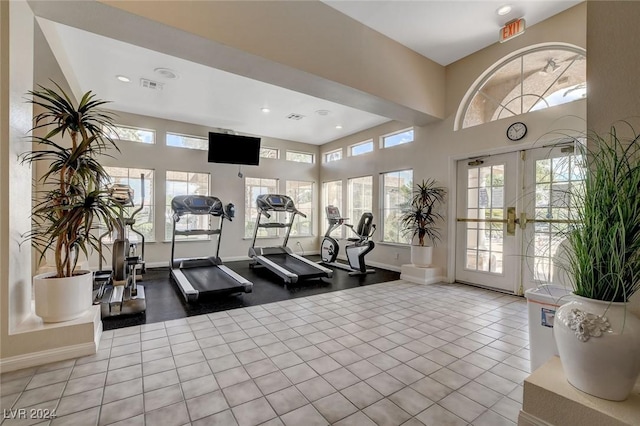 gym featuring light tile patterned floors and french doors