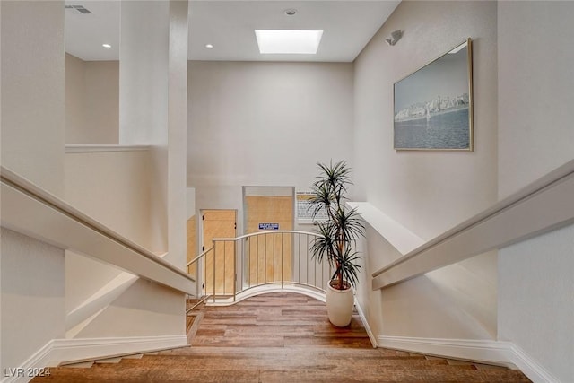 staircase featuring wood-type flooring and a skylight