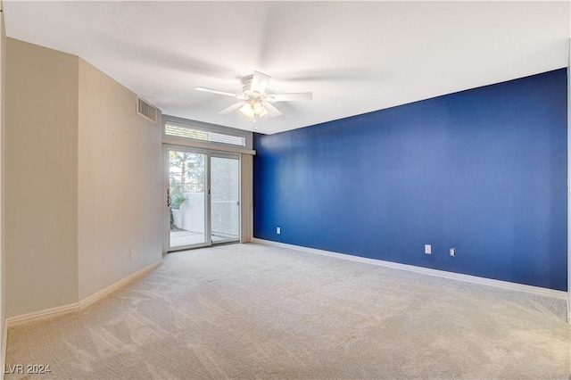 carpeted spare room featuring ceiling fan