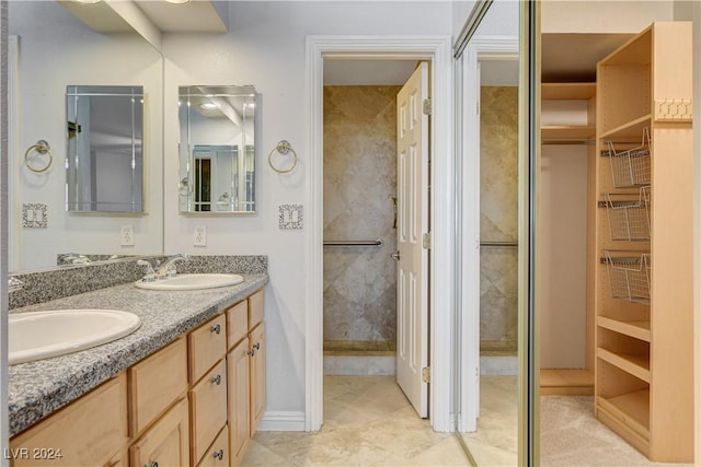 bathroom featuring tile patterned floors, vanity, and a shower with door