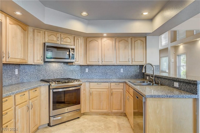 kitchen featuring light stone countertops, appliances with stainless steel finishes, light brown cabinets, and sink