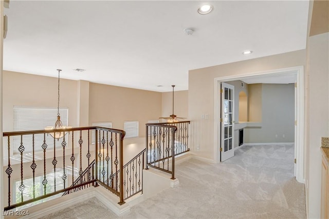 corridor with light colored carpet and a wealth of natural light