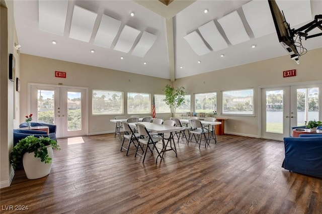 dining space with french doors, high vaulted ceiling, and hardwood / wood-style floors