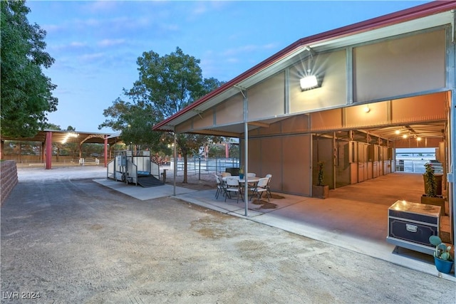 patio terrace at dusk featuring an outbuilding