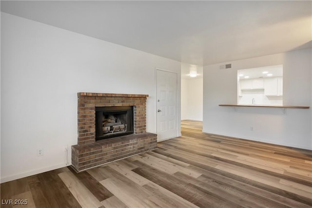 unfurnished living room featuring hardwood / wood-style floors and a fireplace