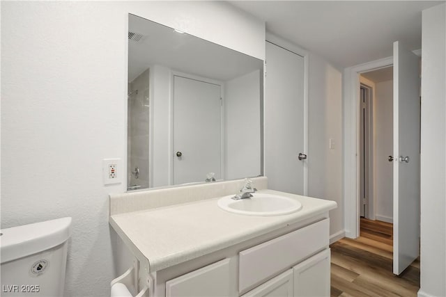 bathroom featuring hardwood / wood-style flooring, vanity, and toilet