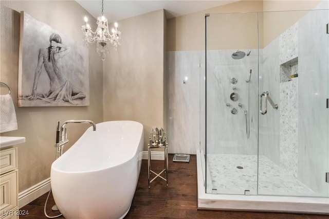 bathroom with vanity, wood-type flooring, shower with separate bathtub, and an inviting chandelier