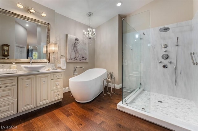 bathroom featuring hardwood / wood-style flooring, vanity, separate shower and tub, and a chandelier