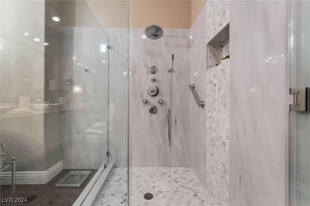 bathroom featuring a shower with door