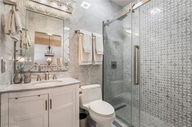 bathroom featuring tile walls, vanity, a shower with door, and toilet