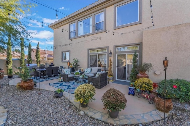 rear view of house featuring an outdoor living space and a patio area