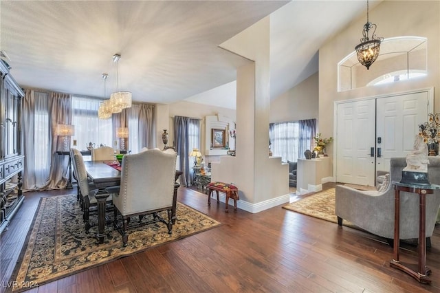 dining room featuring dark hardwood / wood-style flooring, a notable chandelier, and lofted ceiling