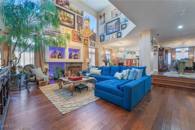 living room with dark wood-type flooring and an inviting chandelier