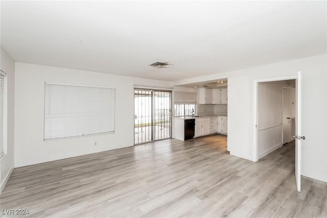 unfurnished living room with light hardwood / wood-style flooring and sink