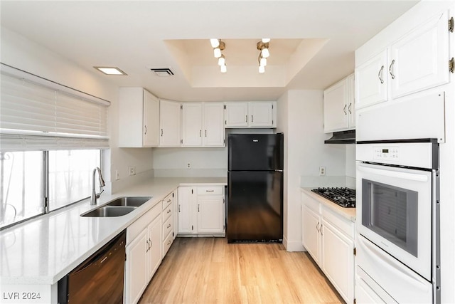 kitchen featuring black appliances, a raised ceiling, white cabinets, and sink