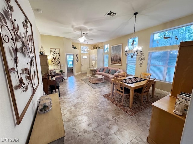 living room featuring ceiling fan with notable chandelier