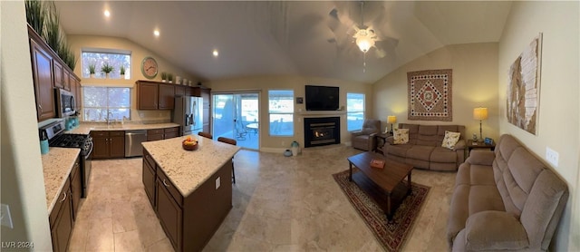 kitchen with a center island, stainless steel appliances, vaulted ceiling, and ceiling fan