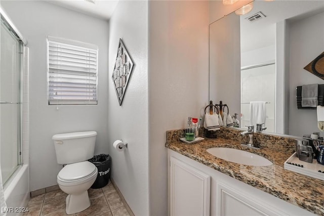 full bathroom with tile patterned floors, vanity, enclosed tub / shower combo, and toilet