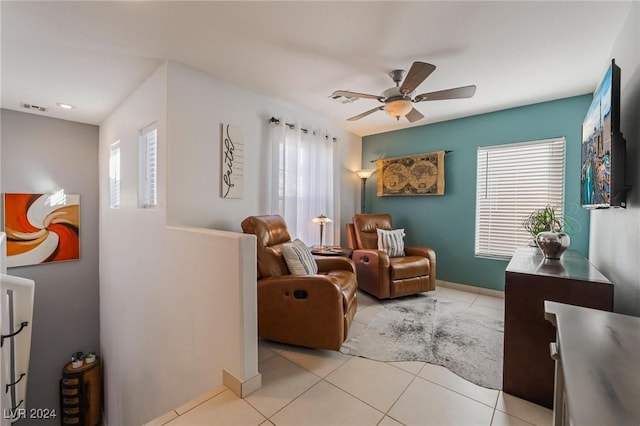 living area with ceiling fan, plenty of natural light, and light tile patterned floors