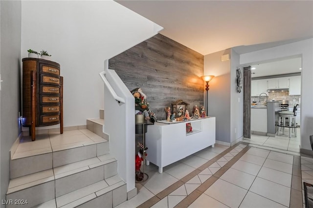 staircase with wooden walls and tile patterned flooring