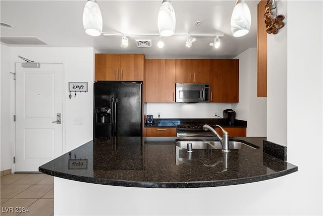 kitchen featuring pendant lighting, light tile patterned floors, black refrigerator with ice dispenser, and sink