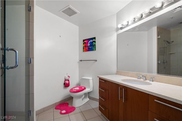 bathroom featuring tile patterned flooring, vanity, toilet, and an enclosed shower