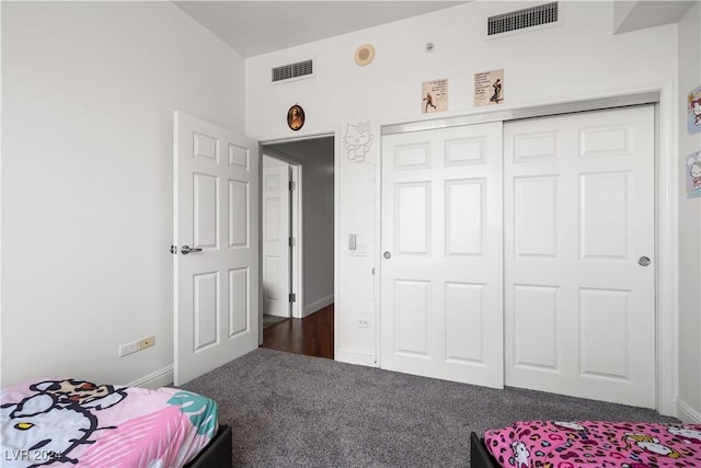 bedroom with dark colored carpet and a closet