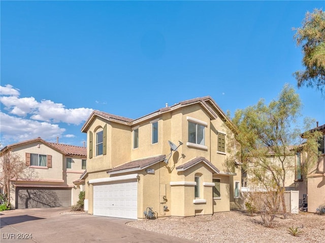 view of front of property featuring a tiled roof, stucco siding, an attached garage, and driveway