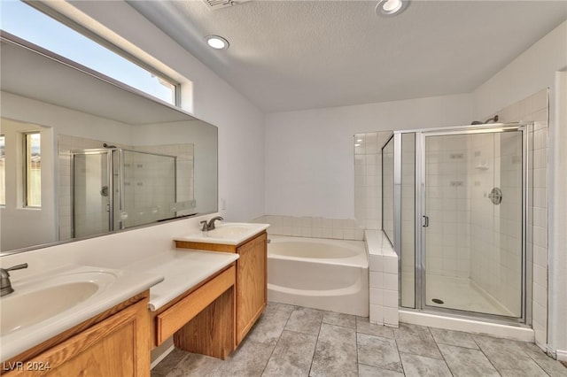 bathroom featuring double vanity, a bath, a stall shower, and a sink