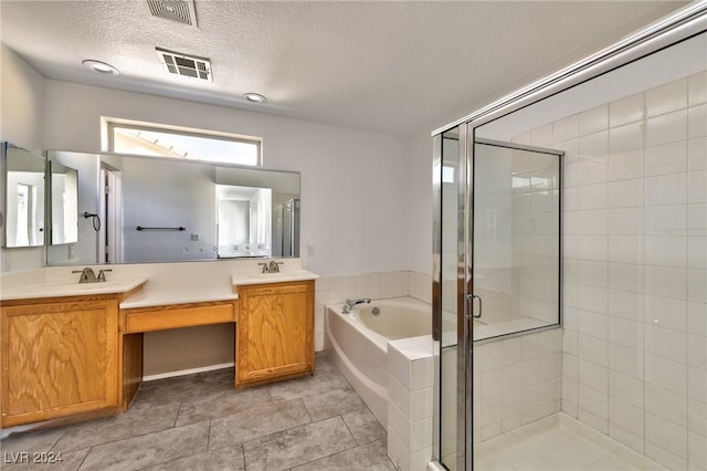 full bathroom with a stall shower, a bath, visible vents, and a sink