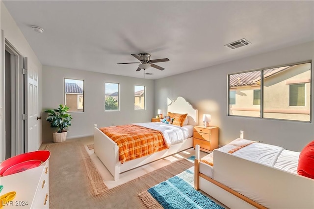 bedroom featuring visible vents, light carpet, and ceiling fan