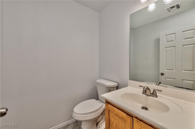 bathroom featuring tile patterned flooring, visible vents, baseboards, toilet, and vanity