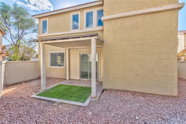 back of property with a patio area, fence, and stucco siding