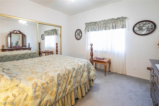 bedroom with a closet, light colored carpet, and multiple windows