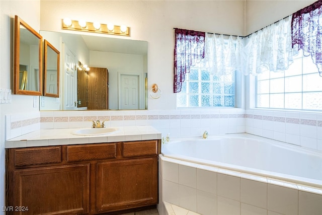 bathroom with tiled bath and vanity