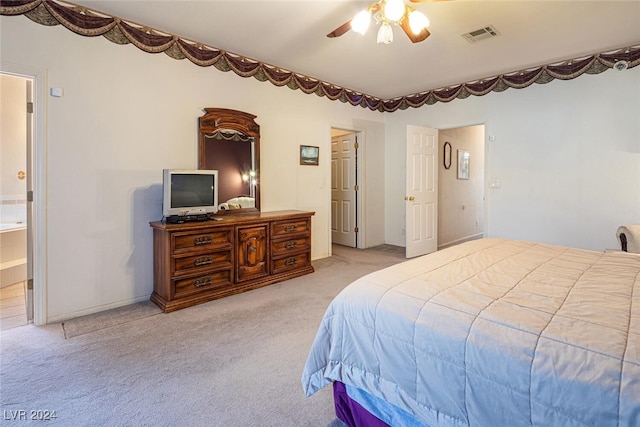 bedroom featuring ensuite bathroom, ceiling fan, and light carpet