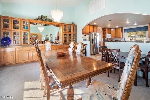 dining area with light carpet and an inviting chandelier