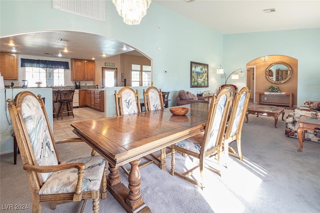 carpeted dining space with an inviting chandelier