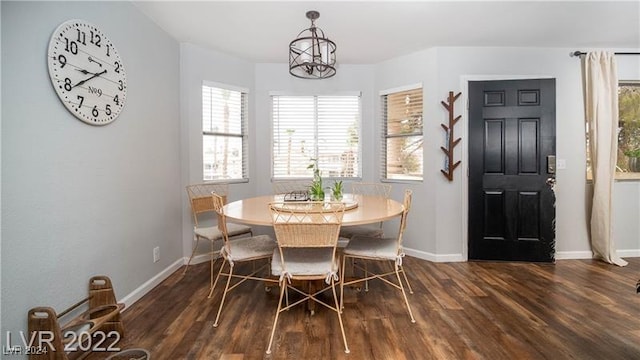 dining room with dark hardwood / wood-style floors and a notable chandelier