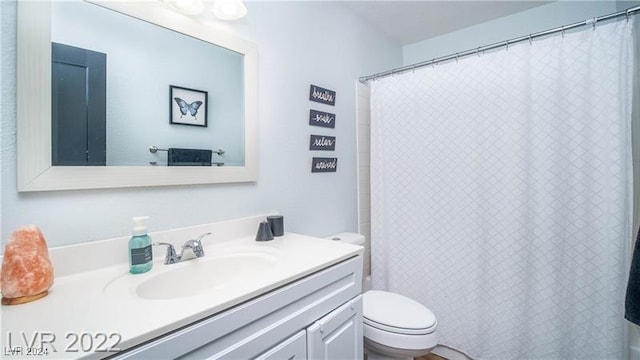 bathroom featuring vanity, toilet, and walk in shower