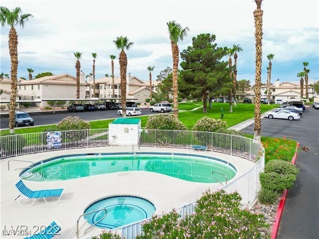 view of swimming pool featuring a hot tub